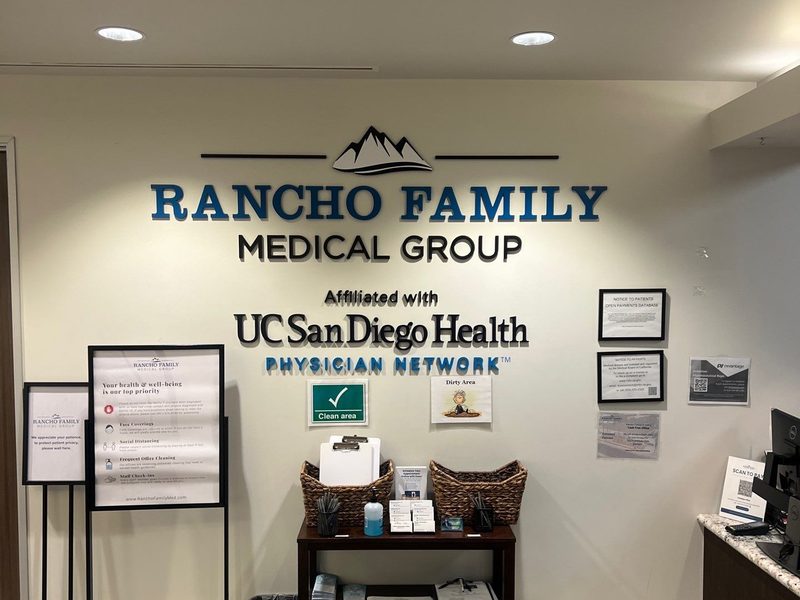 Reception wall sign for Rancho Family Medical Group affiliated with UC San Diego Health